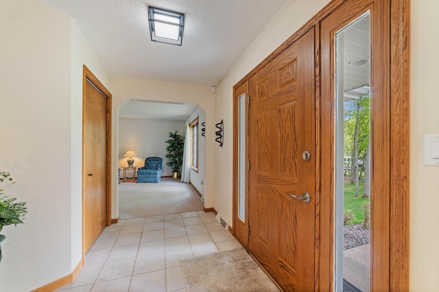 4975 Maribe Dr, Hermantown, MN 55811 - entrance foyer with baseboards, a textured ceiling, light tile patterned floors, and light carpet
