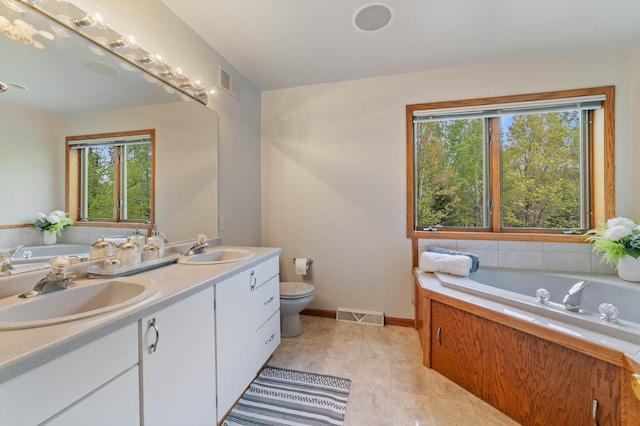 4975 Maribe Dr, Hermantown, MN 55811 - bathroom with double vanity, a garden tub, toilet, tile patterned flooring, and baseboards