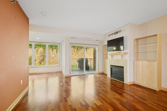 630 Main St N Unit 203, Stillwater, MN 55082 - unfurnished living room featuring wood finished floors, baseboards, and a tiled fireplace