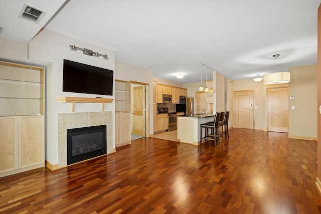 630 Main St N Unit 203, Stillwater, MN 55082 - unfurnished living room with dark wood finished floors, a tiled fireplace, baseboards, and a sink