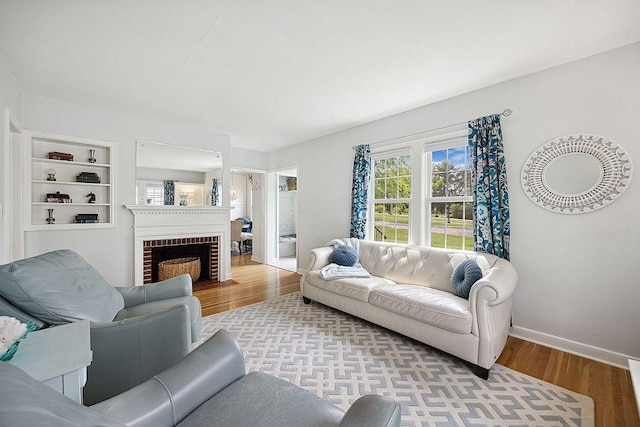 living area with wood finished floors, baseboards, and a fireplace