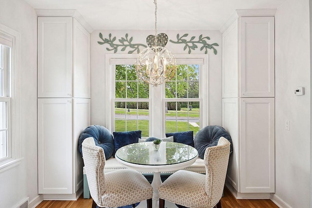 dining area with a chandelier, plenty of natural light, wood finished floors, and baseboards