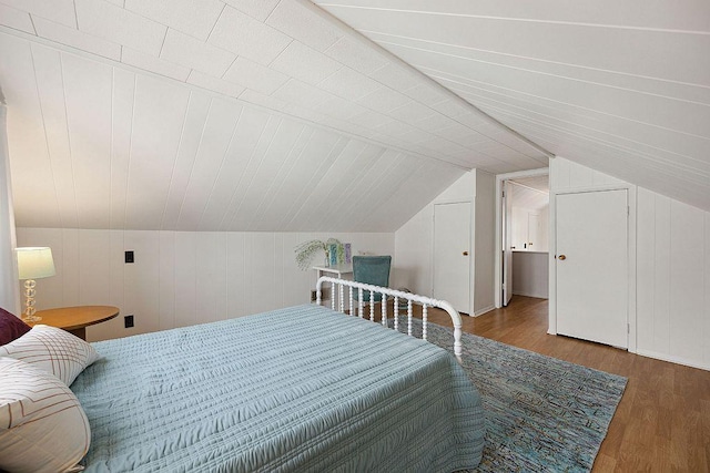 bedroom with wood finished floors and vaulted ceiling