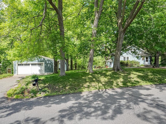 15210 Mckenzie Blvd, Minnetonka, MN 55345 - view of front facade featuring a front yard, an outdoor structure, and asphalt driveway