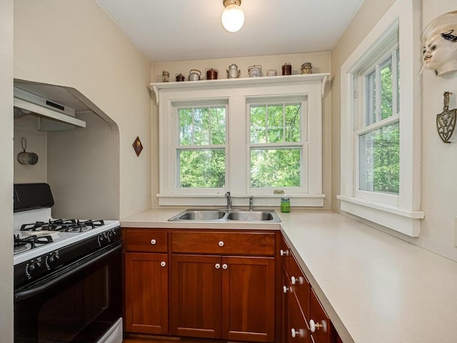 15210 Mckenzie Blvd, Minnetonka, MN 55345 - kitchen with range with gas stovetop, a sink, light countertops, and wall chimney exhaust hood