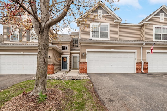 2816 Spy Glass Dr Unit 1713, Chaska, MN 55318 - view of front of home with driveway, a garage, brick siding, and roof with shingles