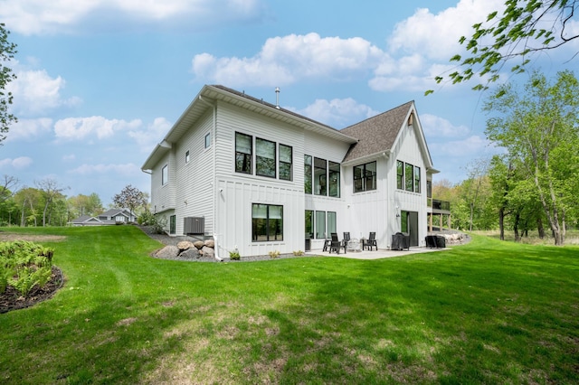 202 176th Ln NE, Ham Lake, MN 55304 - back of house with board and batten siding, a patio, a yard, central AC, and a shingled roof