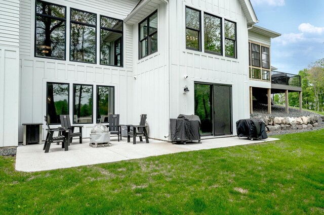202 176th Ln NE, Ham Lake, MN 55304 - back of house with board and batten siding, a yard, and a patio