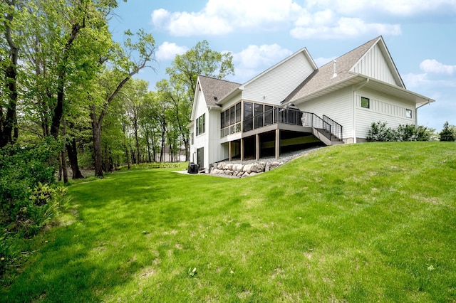 202 176th Ln NE, Ham Lake, MN 55304 - rear view of house featuring a sunroom, a yard, roof with shingles, a wooden deck, and board and batten siding