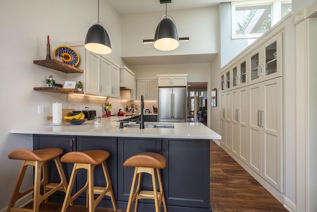2513 Aspen Ln SW, Rochester, MN 55902 - kitchen featuring high quality fridge, a peninsula, a high ceiling, tasteful backsplash, and a sink