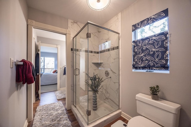 2513 Aspen Ln SW, Rochester, MN 55902 - ensuite bathroom featuring a marble finish shower, wood finished floors, toilet, and baseboards