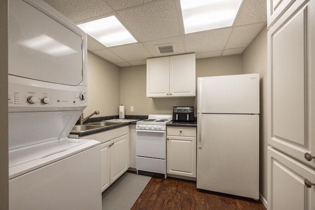 2513 Aspen Ln SW, Rochester, MN 55902 - kitchen featuring white appliances, stacked washer and clothes dryer, a drop ceiling, dark wood-style flooring, and white cabinets
