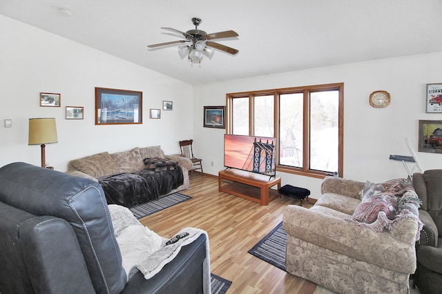 living area featuring lofted ceiling, wood finished floors, and a ceiling fan