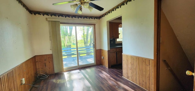 410 Wedgewood Rd, Albert Lea, MN 56007 - empty room with a wainscoted wall, wooden walls, a ceiling fan, and dark wood finished floors