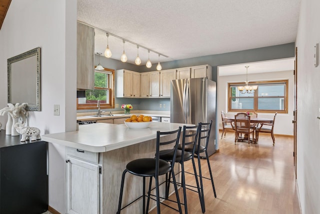 1039 Briar Creek Rd, Eagan, MN 55123 - kitchen with freestanding refrigerator, light wood-style flooring, light countertops, a chandelier, and a textured ceiling