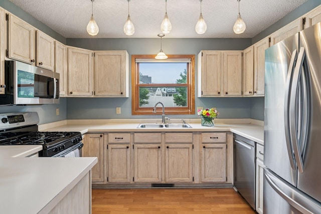 1039 Briar Creek Rd, Eagan, MN 55123 - kitchen featuring appliances with stainless steel finishes, a sink, light brown cabinetry, light countertops, and a textured ceiling