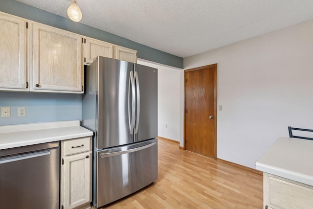 1039 Briar Creek Rd, Eagan, MN 55123 - kitchen with appliances with stainless steel finishes, light countertops, light wood finished floors, light brown cabinetry, and a textured ceiling