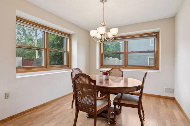1039 Briar Creek Rd, Eagan, MN 55123 - dining room with plenty of natural light, light wood-style flooring, and a chandelier