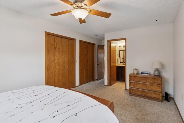 1039 Briar Creek Rd, Eagan, MN 55123 - bedroom featuring light colored carpet, multiple closets, ensuite bathroom, a textured ceiling, and a ceiling fan