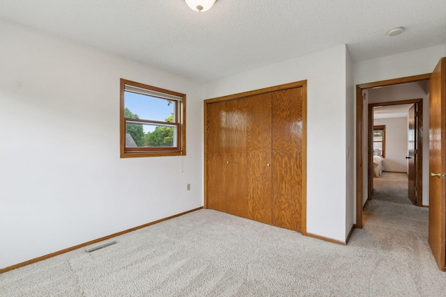 1039 Briar Creek Rd, Eagan, MN 55123 - unfurnished bedroom with light colored carpet, baseboards, a closet, and a textured ceiling