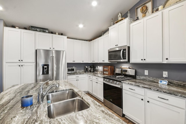 7516 Ochoa Ave NE, Otsego, MN 55330 - kitchen with stainless steel appliances, a sink, white cabinets, recessed lighting, and light stone counters