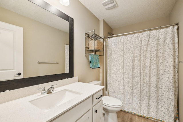 7516 Ochoa Ave NE, Otsego, MN 55330 - bathroom featuring toilet, wood finished floors, vanity, a textured ceiling, and curtained shower