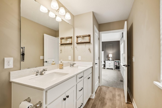 7516 Ochoa Ave NE, Otsego, MN 55330 - bathroom featuring double vanity, wood finished floors, and baseboards