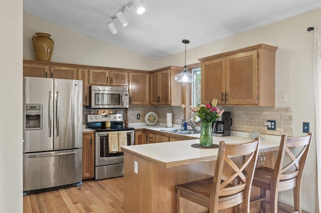 15110 Ute St NW, Ramsey, MN 55303 - kitchen with appliances with stainless steel finishes, a sink, a peninsula, light countertops, and vaulted ceiling