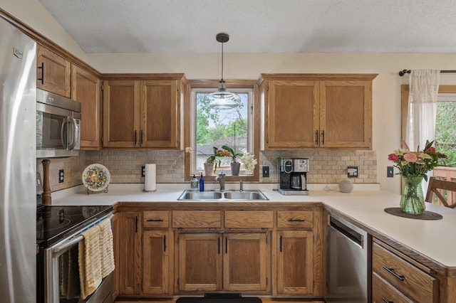 15110 Ute St NW, Ramsey, MN 55303 - kitchen with a sink, appliances with stainless steel finishes, healthy amount of natural light, light countertops, and a textured ceiling
