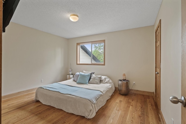 15110 Ute St NW, Ramsey, MN 55303 - bedroom featuring a textured ceiling, light wood-type flooring, and baseboards