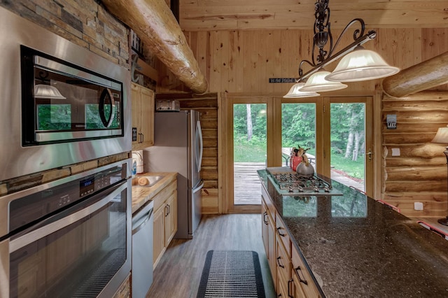 17377 Paradise Shores Rd, Maple Grove Twp, MN 56401 - kitchen featuring log walls, stainless steel appliances, light wood finished floors, pendant lighting, and dark stone counters