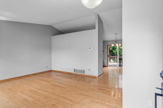 3649 Tower Pond Dr, Anoka, MN 55303 - empty room with wood finished floors, a chandelier, and vaulted ceiling