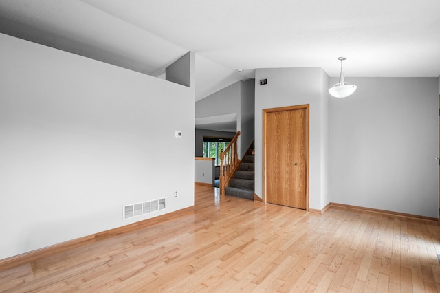 3649 Tower Pond Dr, Anoka, MN 55303 - empty room with hardwood / wood-style flooring, stairway, and vaulted ceiling