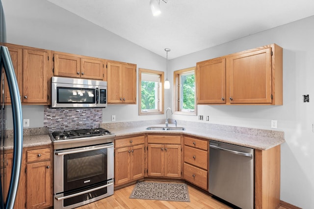 3649 Tower Pond Dr, Anoka, MN 55303 - kitchen with stainless steel appliances, vaulted ceiling, light wood-style flooring, light countertops, and pendant lighting