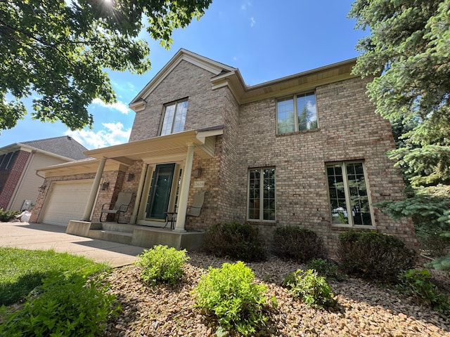 13638 43rd St NE, Saint Michael, MN 55376 - traditional-style home featuring an attached garage, concrete driveway, brick siding, and a porch