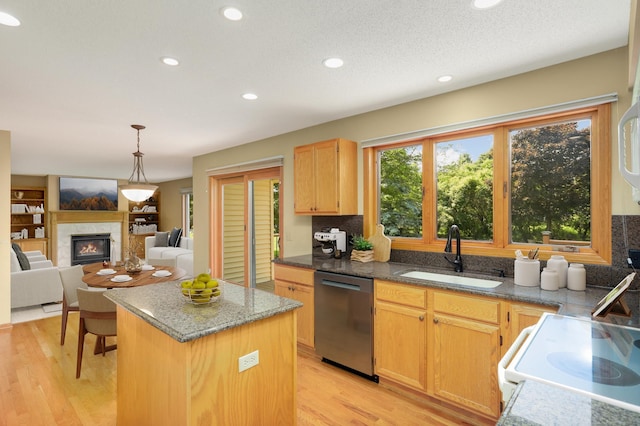 13638 43rd St NE, Saint Michael, MN 55376 - kitchen featuring stainless steel dishwasher, a center island, a glass covered fireplace, light wood finished floors, and hanging light fixtures