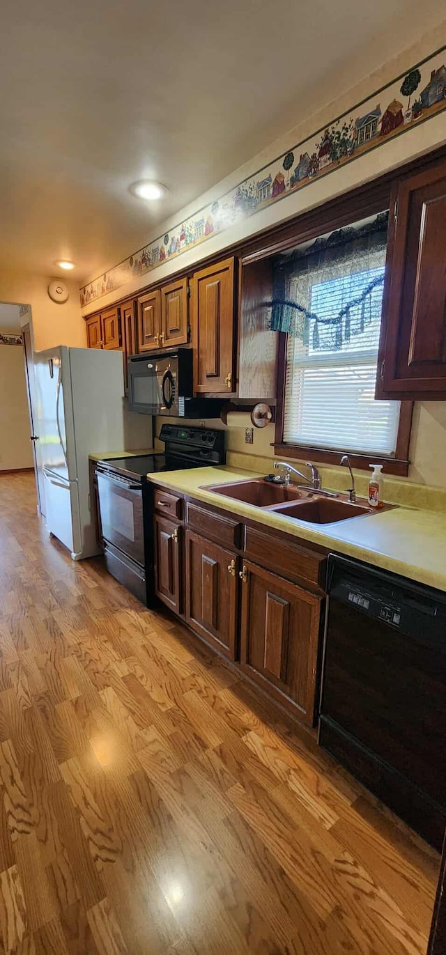 621 16th St, Albert Lea, MN 56007 - kitchen featuring black appliances, a sink, light countertops, and light wood-style flooring