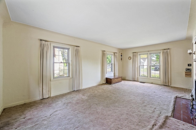 unfurnished living room with carpet flooring and baseboards