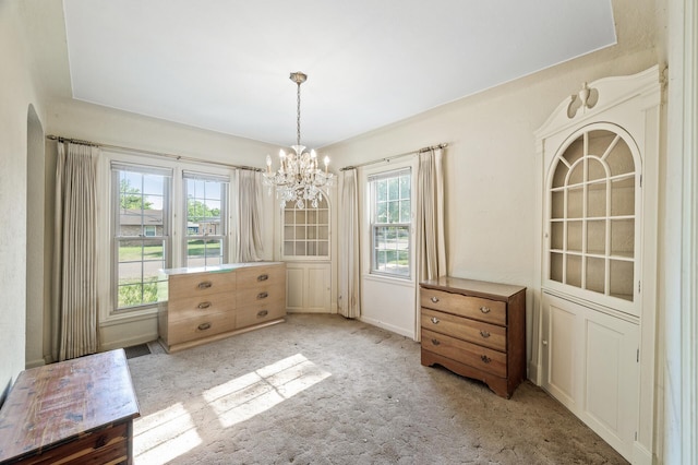 unfurnished dining area featuring a chandelier and carpet