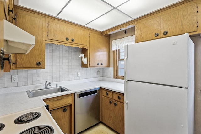 kitchen featuring white appliances, a sink, backsplash, ventilation hood, and light countertops