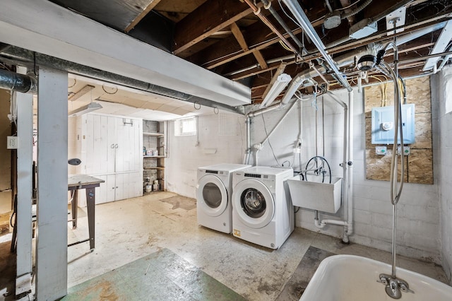 below grade area featuring washing machine and clothes dryer and a sink