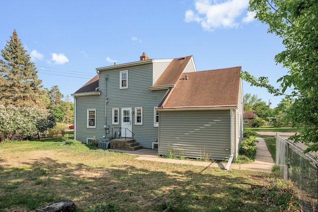 rear view of house featuring a shingled roof, a chimney, and central air condition unit