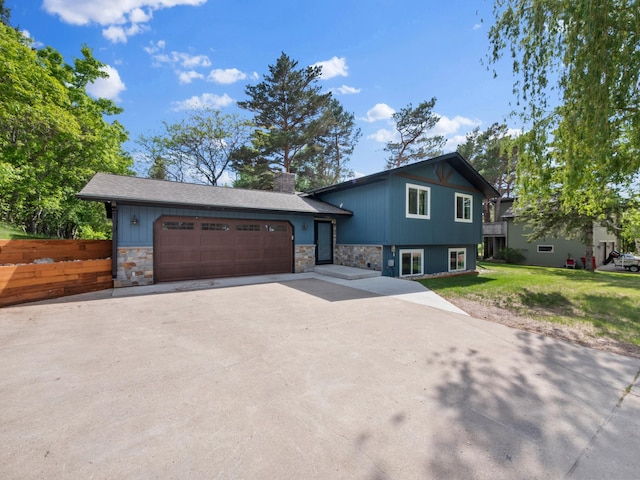 2908 Crestwood Dr NE, Alexandria Twp, MN 56308 - split level home featuring stone siding, concrete driveway, a chimney, an attached garage, and a front lawn
