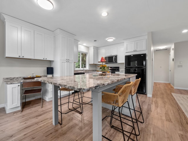 2908 Crestwood Dr NE, Alexandria Twp, MN 56308 - kitchen with black appliances, white cabinets, a breakfast bar, light wood finished floors, and recessed lighting