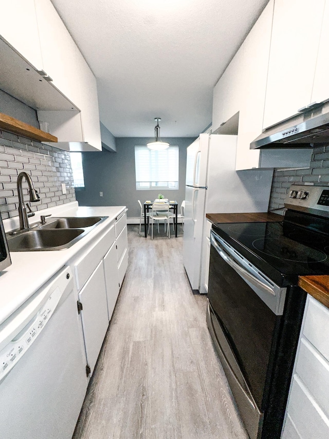 4407 Wilshire Blvd Unit 110, Mound, MN 55364 - kitchen with white appliances, under cabinet range hood, a sink, open shelves, and decorative backsplash