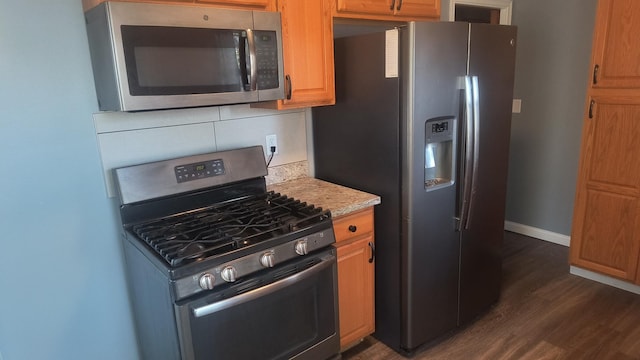 1339 Payne Ave, Saint Paul, MN 55101 - kitchen with stainless steel appliances, dark wood-style flooring, baseboards, and tasteful backsplash