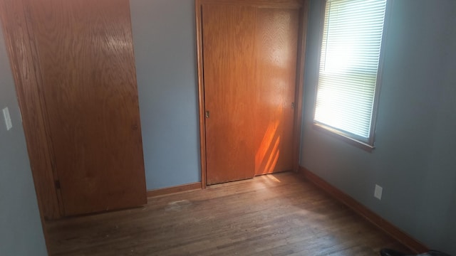 1339 Payne Ave, Saint Paul, MN 55101 - unfurnished bedroom with baseboards, a closet, and wood finished floors
