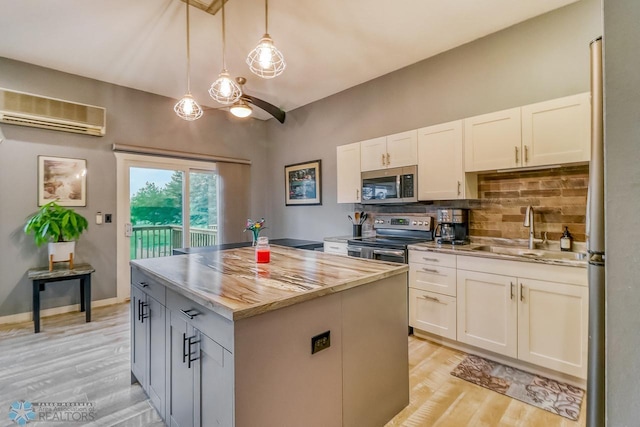 2814 26th Street Cir S, Moorhead, MN 56560 - kitchen with stainless steel appliances, a sink, a wall mounted AC, light wood-style flooring, and tasteful backsplash