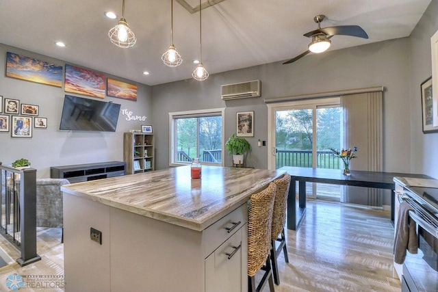 2814 26th Street Cir S, Moorhead, MN 56560 - kitchen featuring a wall unit AC, light wood-type flooring, ceiling fan, pendant lighting, and electric range oven