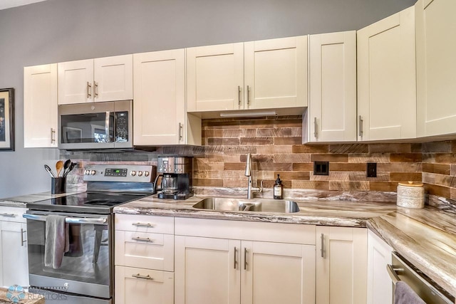 2814 26th Street Cir S, Moorhead, MN 56560 - kitchen featuring appliances with stainless steel finishes, a sink, decorative backsplash, and white cabinetry
